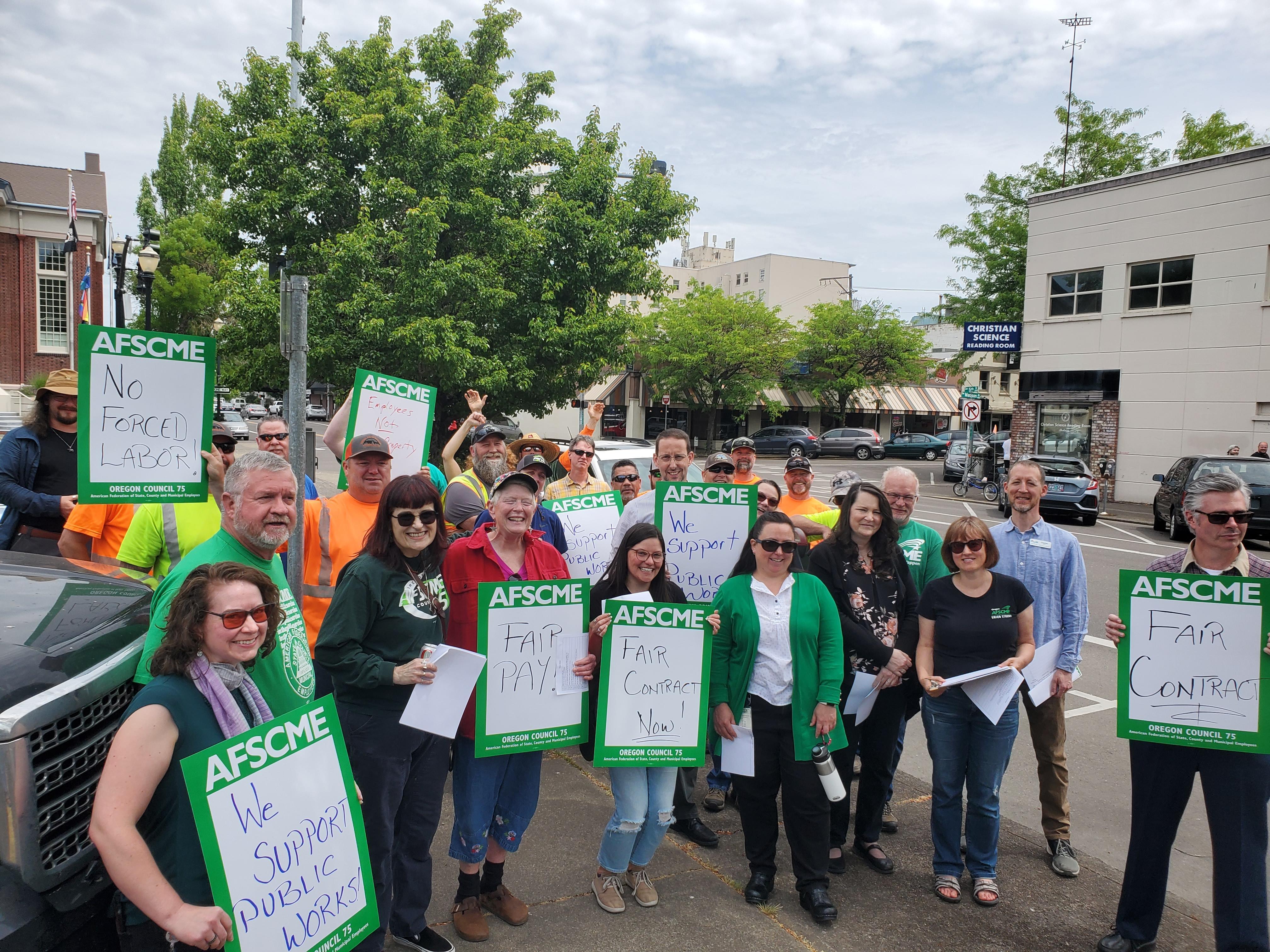 Multiple people rallying outside the Madison Avenue Building in Corvallis.